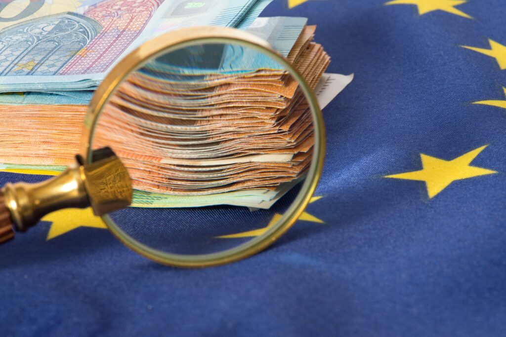 Magnifying glass and euro notes as a symbol of declining discretion