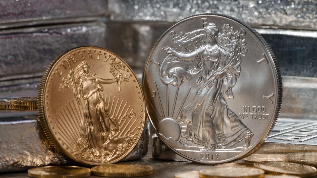 Un American Eagle de oro y plata frente a lingotes de plata.