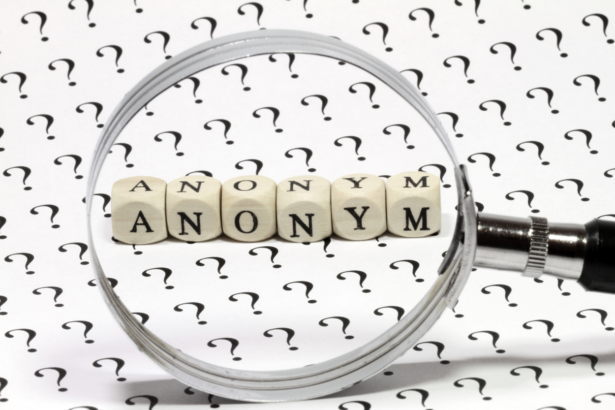 The word anonymity viewed through a magnifying glass.