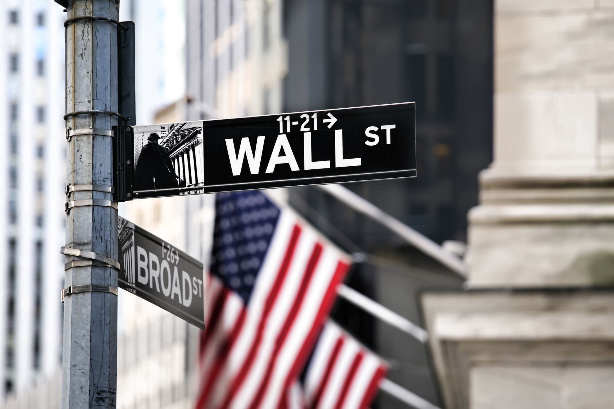 Wall Street sign with American flags in the background