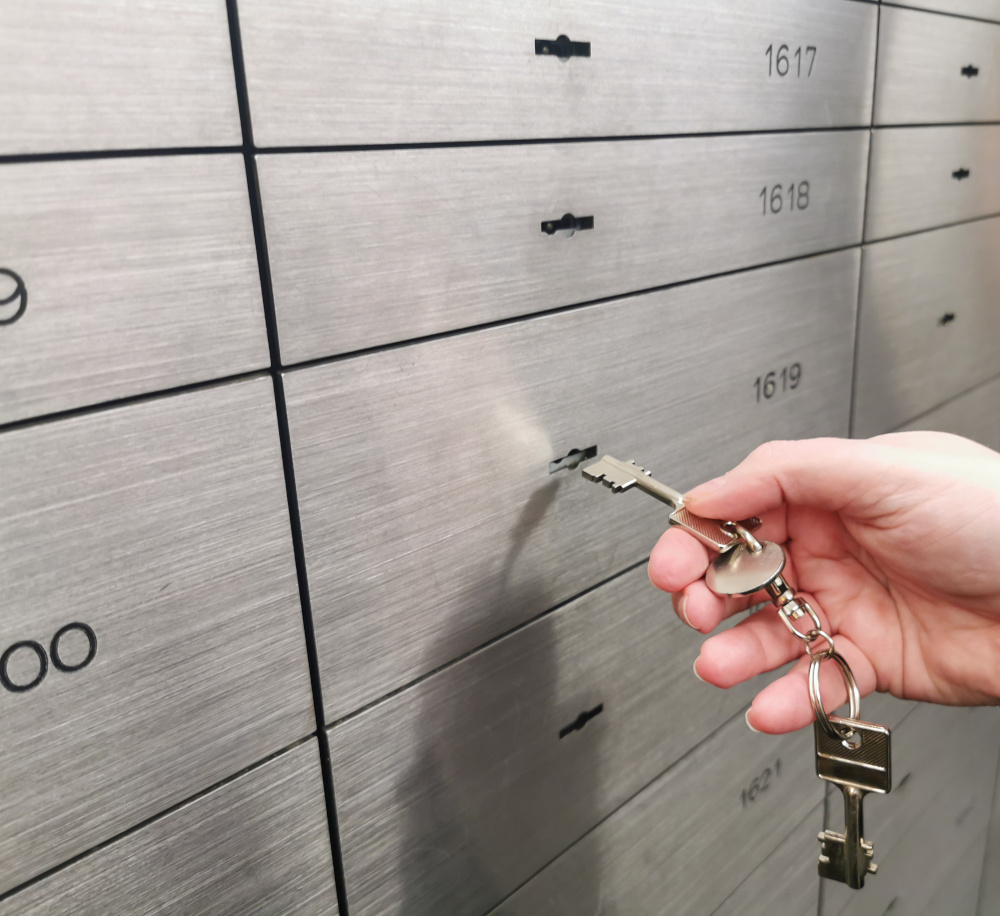 Locked safe deposit box is opened by means of a key