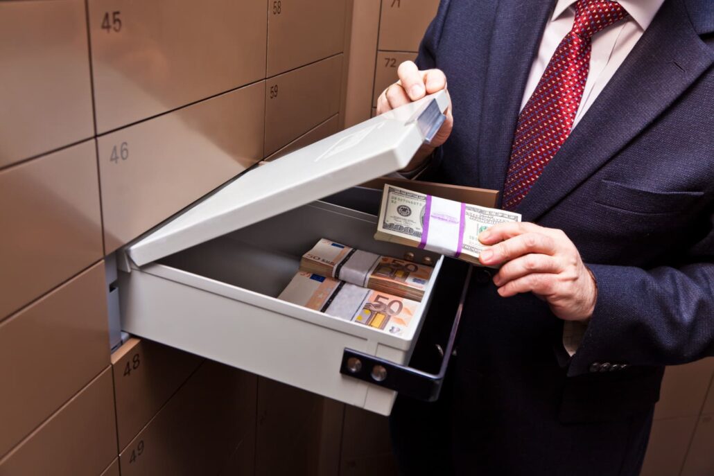 Person in suit showing an open bank safe deposit box