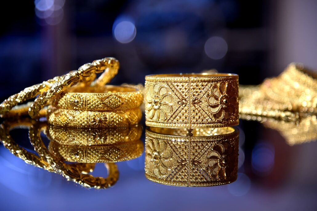 several golden jewellery pieces on a reflective background